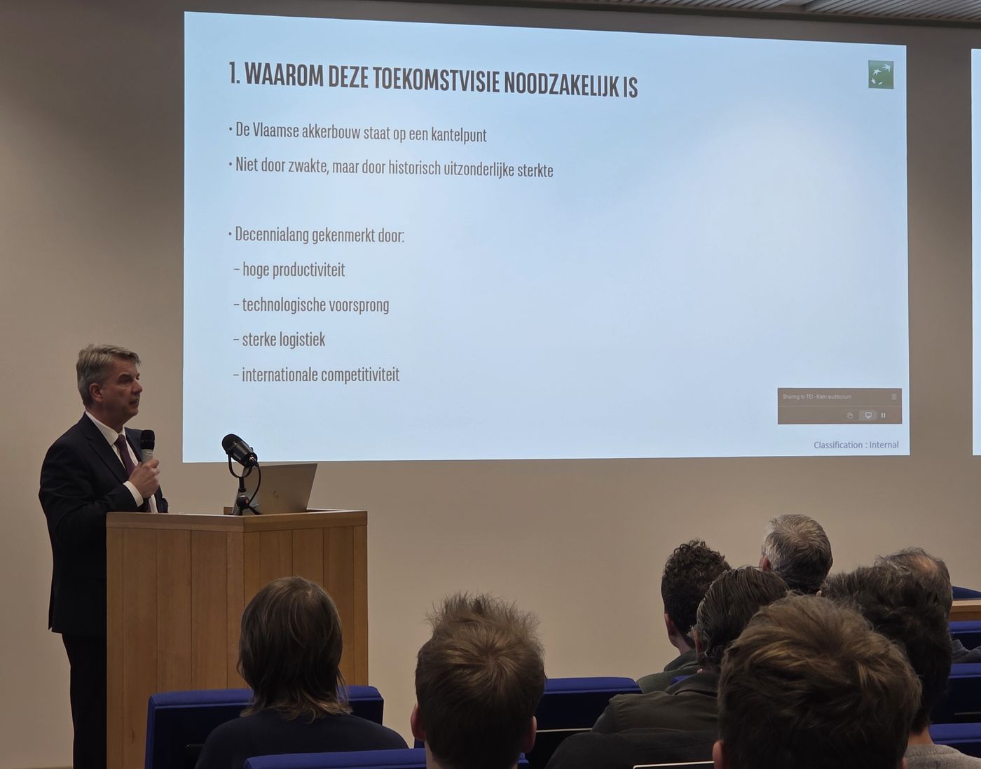 Auditorium op de Actiedag Carbon Removal & Carbon Farming: een spreker aan het spreekgestoelte voor een volle zaal in het Herman Teirlinckgebouw van de Vlaamse overheid